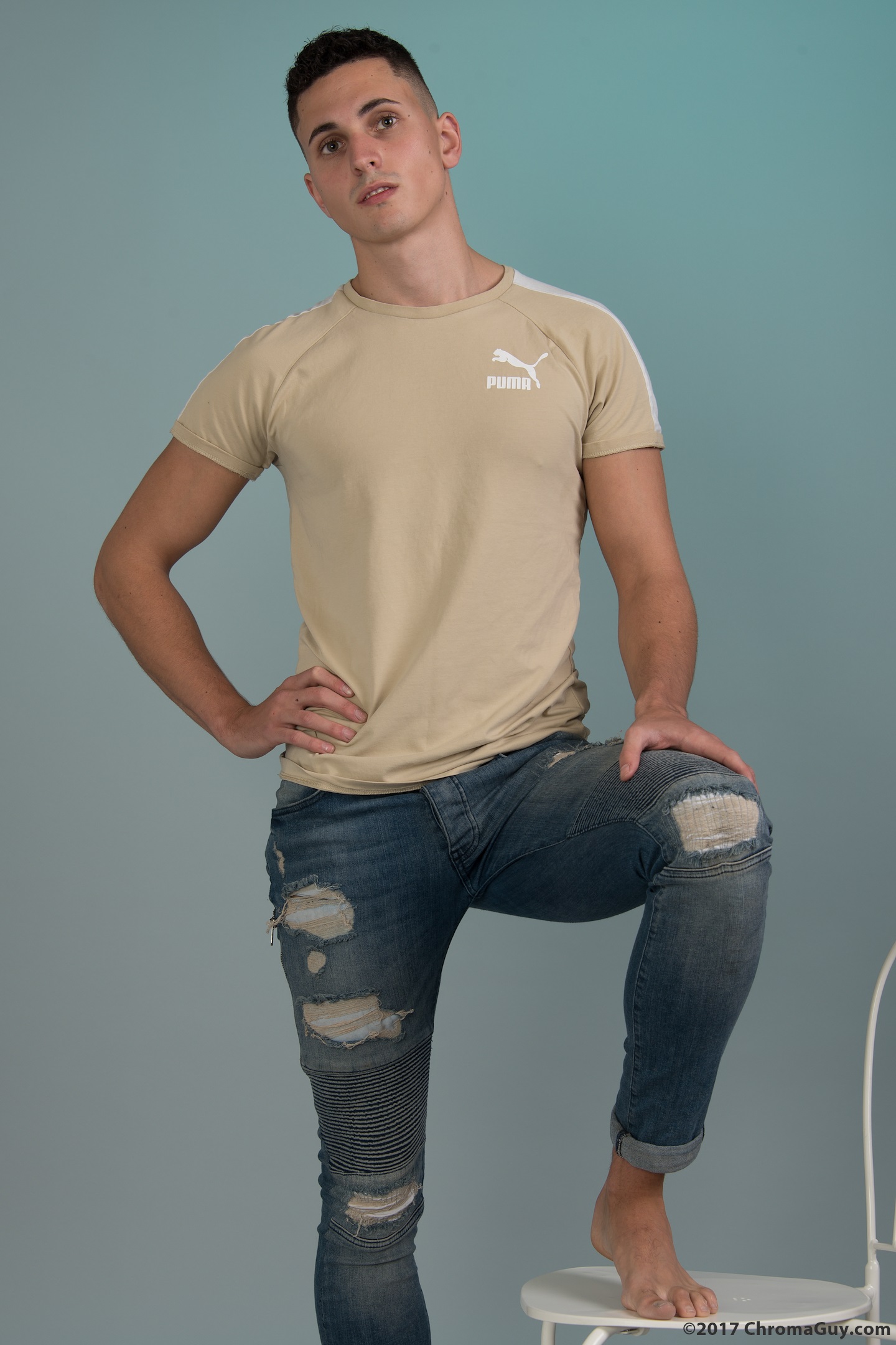 Guy in jeans with one foot up on chair